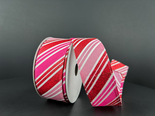 A partially unrolled spool of 1.5x10Y Red Glitter-Fuchsia-Pink-White Diagonal Stripe Satin (15402-09-12) is displayed against a dark background, highlighting its vibrant pattern and sheen.