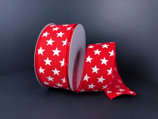 A spool of 1.5X10Y Red Satin/White Stars Ribbon 41223-09-12 is partially unrolled and set against a black background, showcasing its red fabric with white stars.