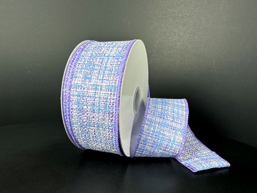 The 1.5X10Y Lavender White Blue Embellished Tweed Ribbon, with wired lavender edges and a woven pattern in lavender, white, and blue, is partially unrolled against a dark background.