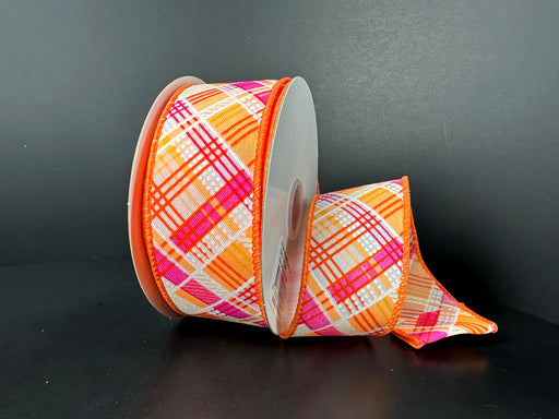 A 1.5 x 10Y roll of Neon Orange Fuchsia White Diagonal Cabot Plaid Ribbon (41523-09-19) is on a dark surface, partially unrolled to display its vibrant colors and intricate design.