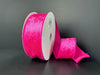 A partially unrolled 1.5X10Y Fuchsia Lush Velvet Ribbon 41549-09-28 with a vibrant, soft texture is set against a dark gray background.