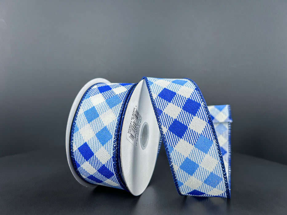 Two spools of 1.5X10Y White Navy Blue Linen Diamond Ombre Ribbon are set against a dark background, with one wired ribbon partially unrolled to display its checkered pattern.