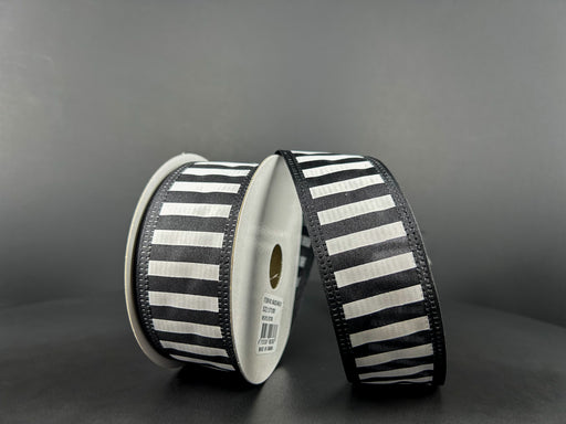 Two spools of 1.5X10Y Black Satin-White Stripes/Black Edge Ribbon 46425-09-21 rest on a gray background. One spool stands upright while the other leans against it, with the wired ribbon partially unrolled and elegantly draped in front.