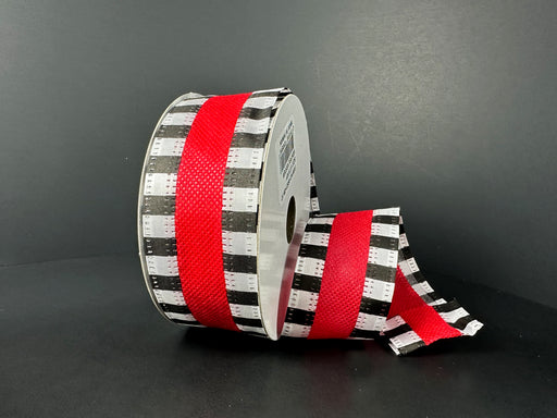 A partially unrolled roll of 1.5X10Y Red Flat Breeze/Black And White Stripe Edge Ribbon (46521-09-12) is set against a dark backdrop, showcasing its striking black and white checkered pattern with a central red stripe.