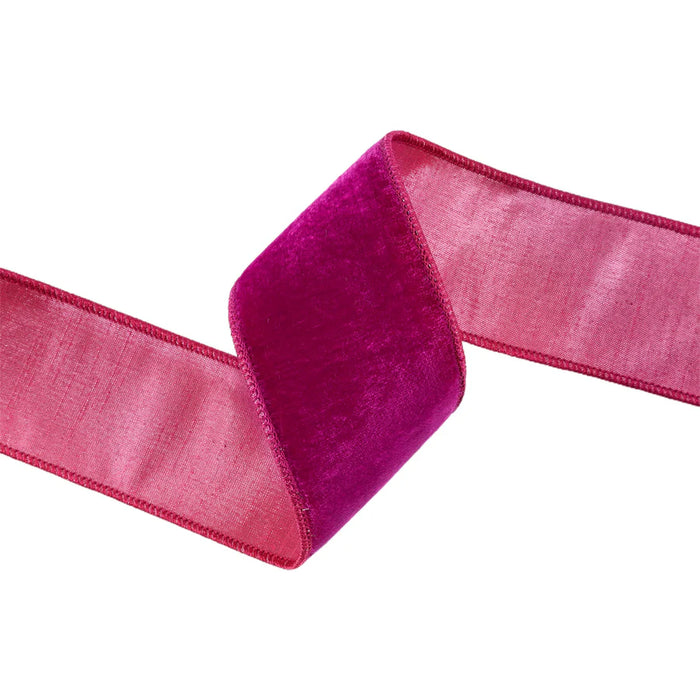 The 2.5" Hot Pink Premium Velvet Ribbon with Pink Dupioni Backing 7049W-185-63C elegantly curves on a pristine white background, featuring a dupioni backing that's subtly darker on one side.