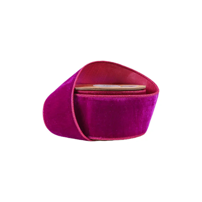 A magenta velvet clutch purse with a curved design, featuring a wooden interior and accented with a 2.5" hot pink premium velvet ribbon with pink Dupioni backing for added flair.