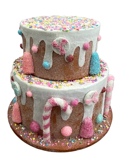 An 8" by 9" Blue and Pink Two Tier Cake (85788BLPK), decorated with white icing drips, vibrant sprinkles, and a stunning mix of pastel-hued candies such as lollipops and candy canes.