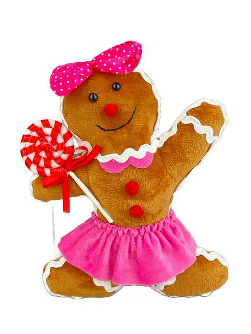 The 9" by 7" by 2" Brown Gingerbread Girl Ornament (product code: 85834BN) is an enchanting gingerbread doll. Adorned with a pink polka dot bow, she wears a frilly skirt and holds a red and white striped lollipop. Accentuated with buttons and outlined in white icing, her joyful design is utterly captivating.