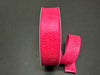 A roll of 1.5X10Y Fuchsia Flower Embossed Ribbon, featuring a floral pattern against a dark background.