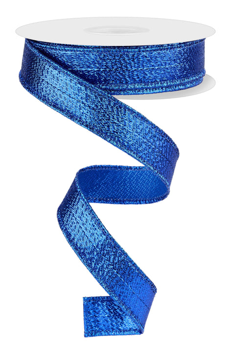 A spool of the 7/8"X10YD Royal Blue Metallic Ribbon RG0739925 is unwinding, creating a spiraling pattern on a white background. The textured, sparkly surface of this ribbon adds a vibrant and eye-catching effect.