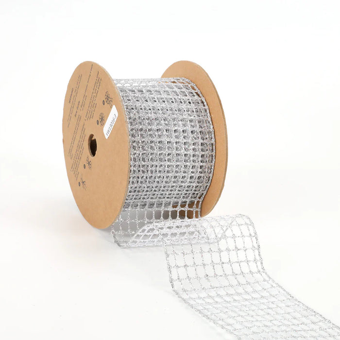 A spool of 2.5" Silver Netting Wired Ribbon (WR-10210-063-10) with a grid pattern is partially unrolled. The spool features cardboard ends adorned with printed text and symbols. The ribbon's shiny and reflective quality indicates it's perfect for decorative use, adding an elegant touch to any project or setting.