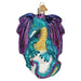 The Fantasy Dragon Ornament by Old World Christmas (12631) showcases a glittery design in teal and purple, highlighting its outspread wings and a sparkling white orb held by its elegantly wrapped tail. Accentuated with gold and intricately detailed, this mythical creature is truly enchanting.