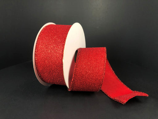 A partially unspooled roll of Red All Flat Glitter, 1.5X10Y Ribbon (X820609-12) sparkles with a textured look on a black background; the wired ribbons spool is white.