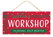 The 12.5"L x 6"H Santa's Workshop Sign, product number AP8899, is designed in festive red and white with emerald accents and playful polka dots. It prominently displays "Santa's Workshop" in large letters, while a green rectangular banner announces "Seasonal Help Wanted." Green glittery details enhance the sign, which hangs from a brown string.