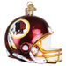 The Washington Helmet 73217 Old World Christmas Ornament is shaped like a Washington helmet, featuring a red design embellished with yellow and white details and showcasing a logo with a feathered headdress.